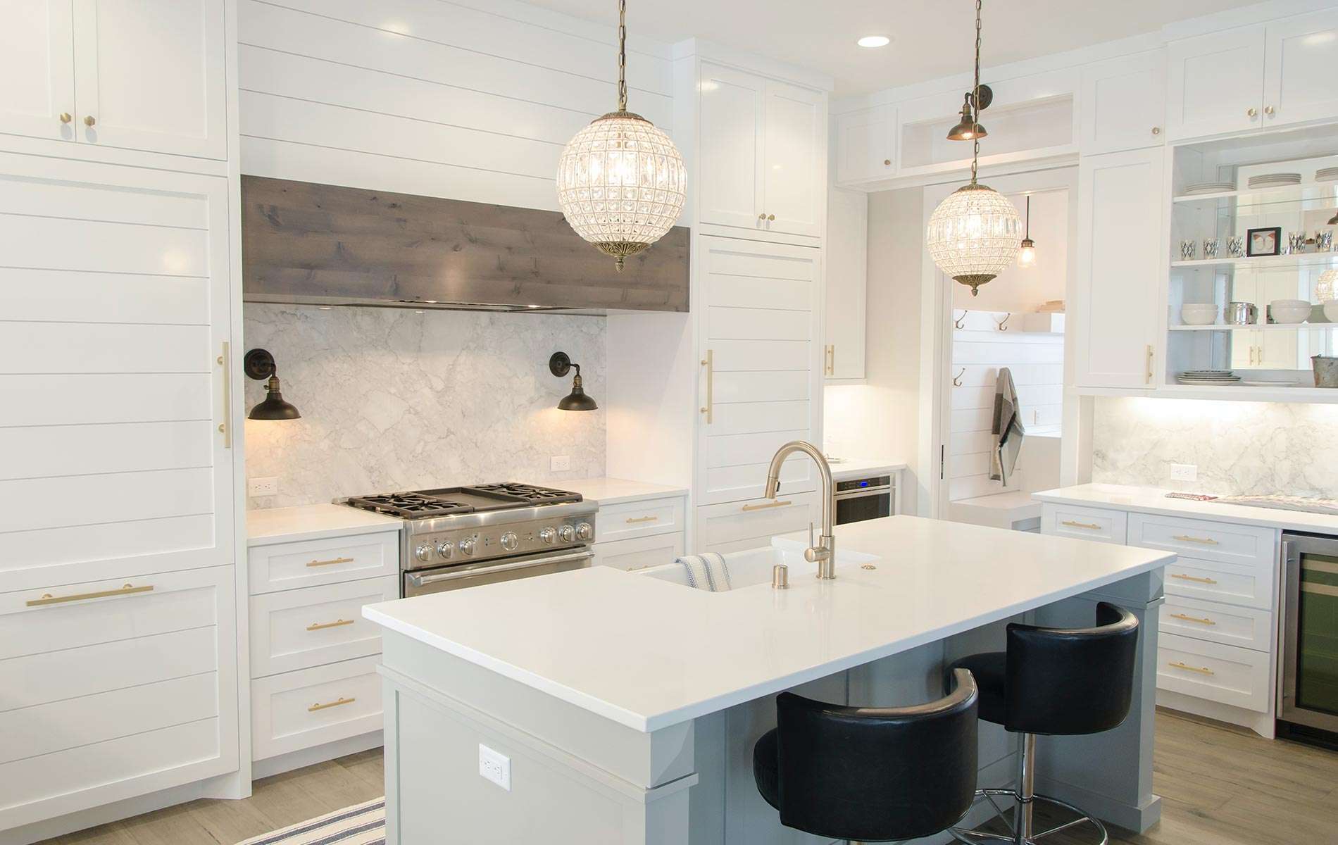 Modern white kitchen with island and pendant lights in a Gainesville FL home for sale, showcasing desirable features in local real estate listings