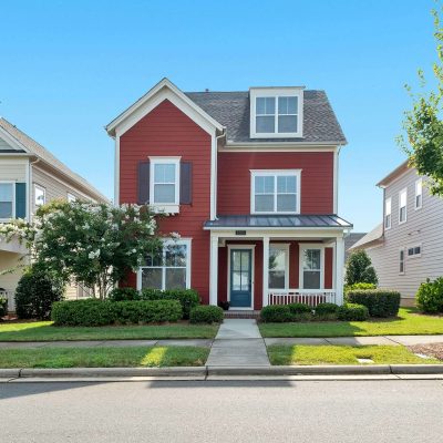 Two-story red house with white trim and blue shutters in Gainesville FL, representing homes for sale by Jonathan Sherrod in local real estate listings